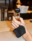 NightCap Bottle Tops reusable drink protection bottle cover on a beverage bottle with included keychain pouch, helping protect drinks from unwanted contaminants while preserving carbonation.